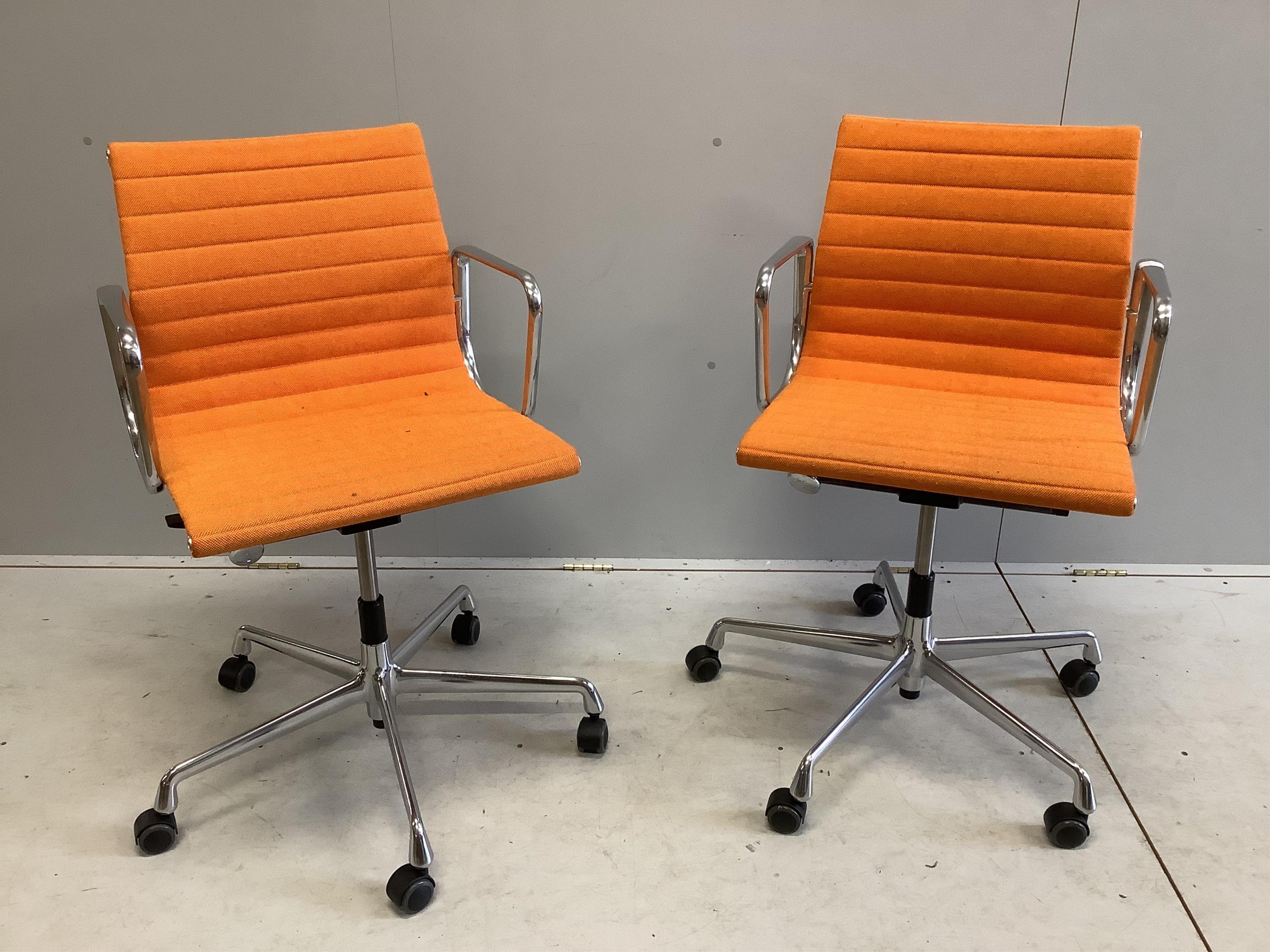 A pair of Vitra Eames EA117 orange fabric office chairs, width 57cm, depth 52cm, height 89cm. Condition - fair to good